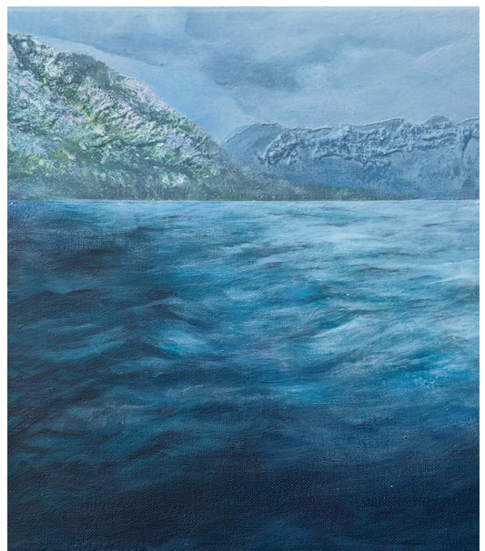 A landscape painting depicting a vast, textured blue sea in the foreground with rugged mountains covered in patches of snow under a cloudy, overcast sky.
